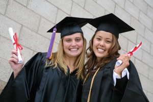Two young women celebrating their graduation with diplomas